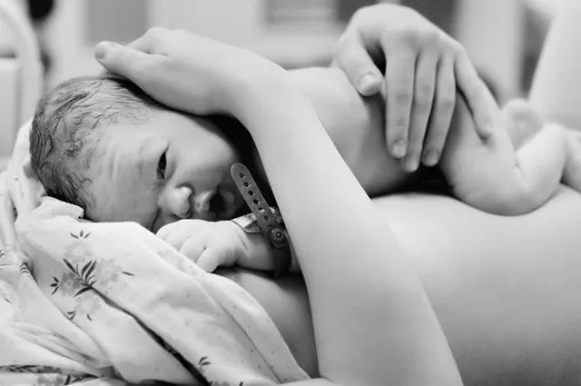 Neugeborenes im Arm seiner Mutter